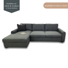 Galaxy Sofa Bed with Chaise in grey fabric, shown with extended chaise on the left and black accent cushion. Available to see in store.
