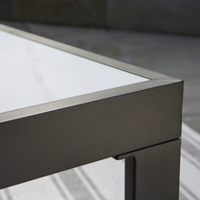 Close-up of marble-look coffee table corner with black frame